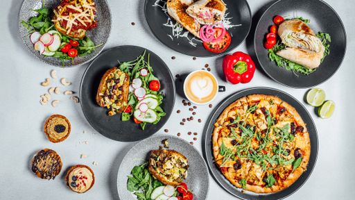 A top view  of the various freshly made delicious food on plates on the gray surface