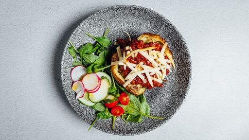 A top view of the delicious potato stuffed with bolognese sauce and cheese on a plate