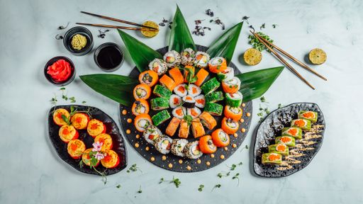 A top view of plates of various delicious fresh sushi rolls