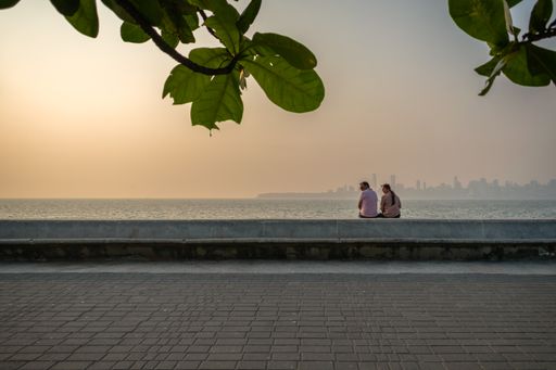 A couple enjoying the sea view and the sunset at Nariman Point in Mumbai, India