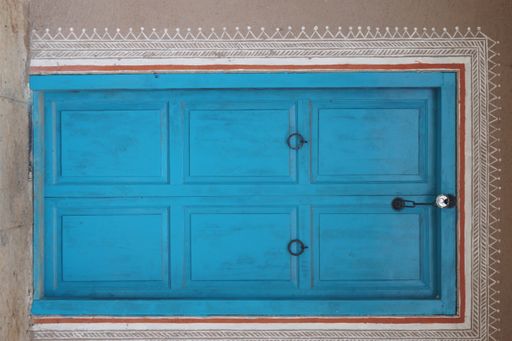 An old wooden door with a white patterned frame