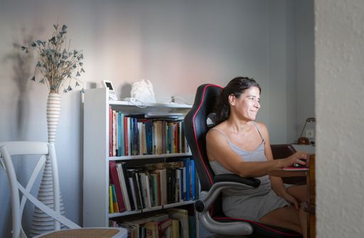 A middle-aged Hispanic female working from her home office with books