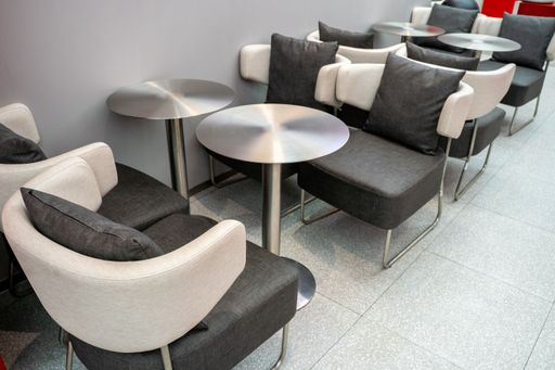 Modern lounge seating area with sleek metal tables and comfortable chairs, ideal for casual meetings or relaxation.