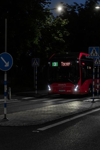 A vertical shot of a bus driving at night in the city of Ulricehamn, Sweden