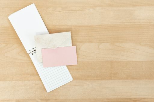 A wedding invitation mockup card with paper and envelope on the wooden desk with copy space