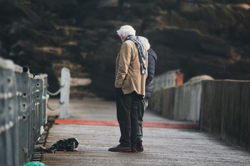 A beautiful retired couple standing and admiring the view on the old bridge