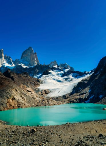 people at the edge of the lagoon. Fitz Roy Mountain and Laguna de los Tres in El Chalten.