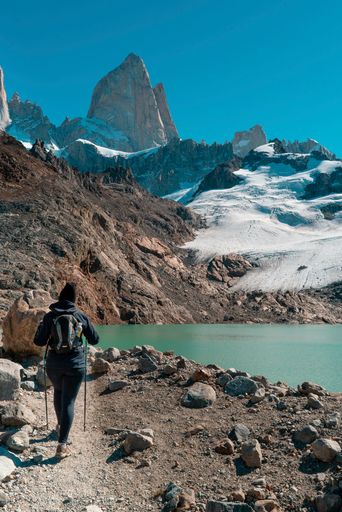 People trekking through the mountains. with their sticks they walk on the rocks.
