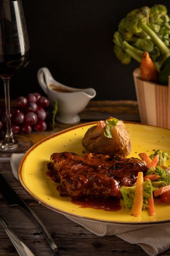 A vertical closeup of delicious steak with sauce and vegetable salad.