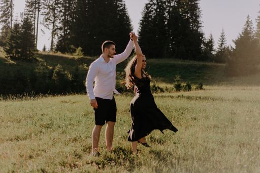 A young romantic couple dancing and having fun on a field
