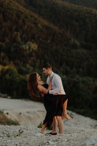 A young couple posing romantically on a mountain with a view