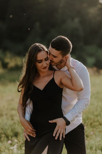 A vertical shot of a romantic couple posing on a meadow