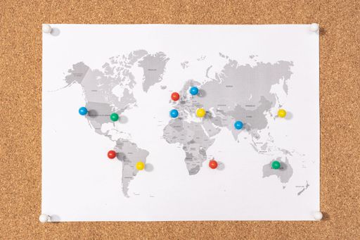 Planning Travel destination concept. Pushpins on world map on Corkboard