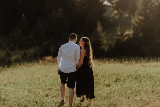 A young romantic couple walking and having fun on a field
