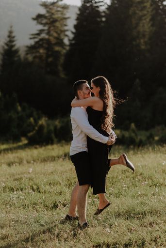 A vertical shot of a romantic couple posing on a meadow