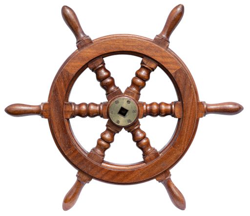 Wooden steering wheel rudder of a small boat isolated on white background. Old ship rudder