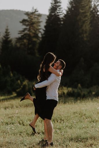 A young romantic couple posing and having fun on a field