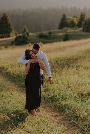 A vertical shot of a romantic couple posing on a meadow