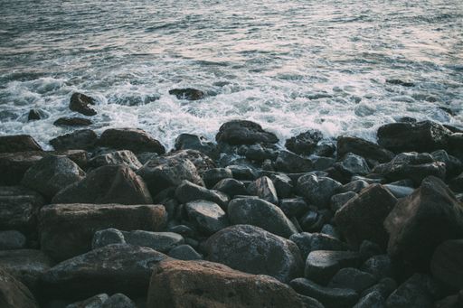 A closeup of rocks on the shore surrounded by the sea in the daylight