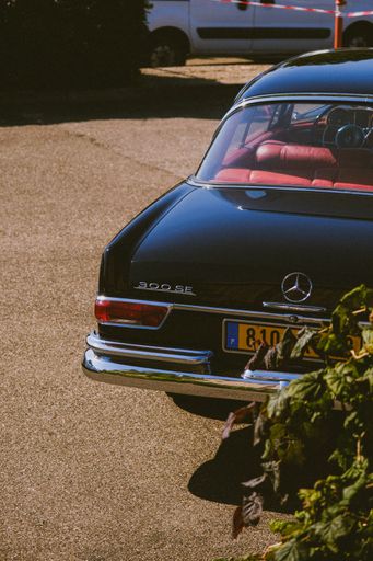 A vertical shot of a black vintage Mercedes parked outdoors in Strasbourg, France