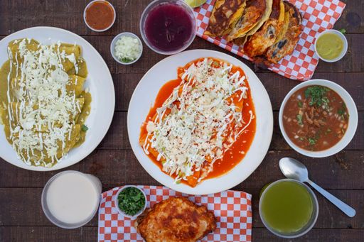 A top view of enchiladas rojas, green enchiladas, birria and charro beans