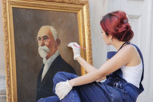 A closeup shot of a Hispanic female painting in an art studio