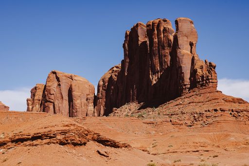 Majestic rock formations in Monument Valley under a clear blue sky, showcasing the stunning desert landscape.