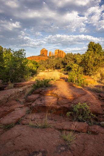 Scenic view of Cathedral Rock in Sedona, Arizona with dramatic sky and vibrant red rocks during sunset.