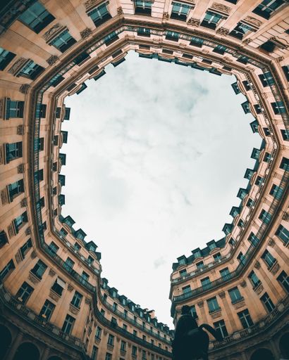 A vertical low angle shot of historic buildings on cloudy sky background in Paris, France