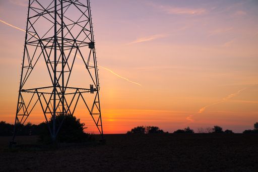 A transmission tower silhouette at sunset