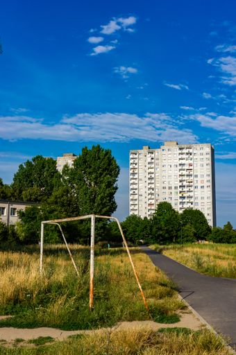A beautiful view of a long pathway gleaming under the cloudy blue sky in the park