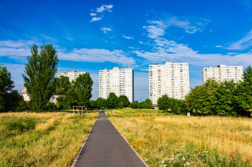 A beautiful view of a long pathway gleaming under the cloudy blue sky in the park