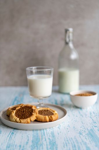 A vertical shot of delicious cookies and a bottle of milk on a tagle