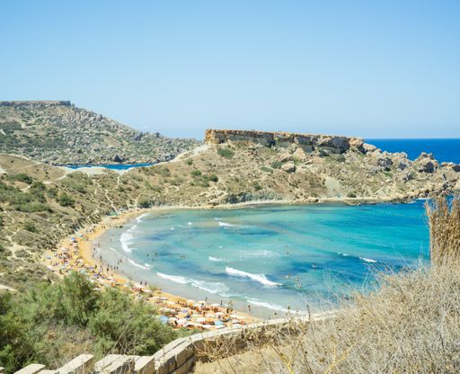 An aerial shot of the beautiful Riviera Beach in Malta under a clear blue sky