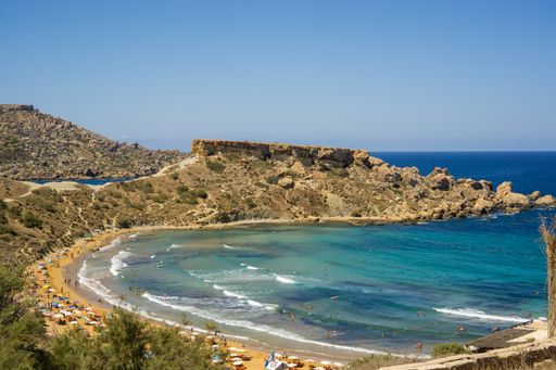 An aerial shot of the beautiful Riviera Beach in Malta under a clear blue sky