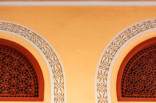 Jaipur, Rajasthan, India - February 2012: Details of carvings on latticed windows and lunettes on the yellow walls of the ancient City Palace.