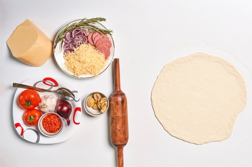 A top view of pizza ingredients isolated on white background
