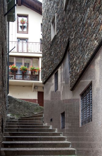 A vertical shot of stairs surrounded by buildings during the day