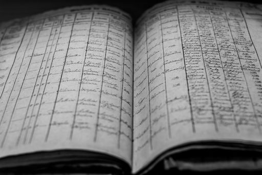 A closeup of an old book of local records with list of residents' names and information