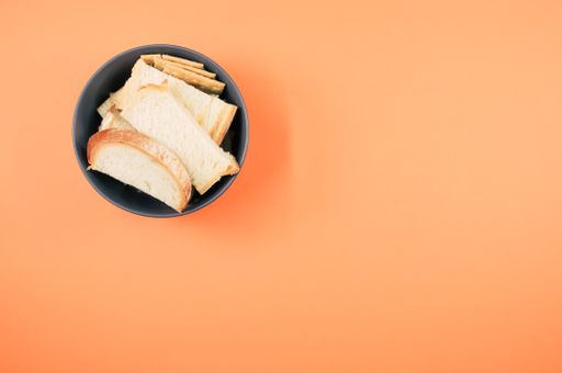 salty crackers with slices of organic bread in a bowl on an orange background