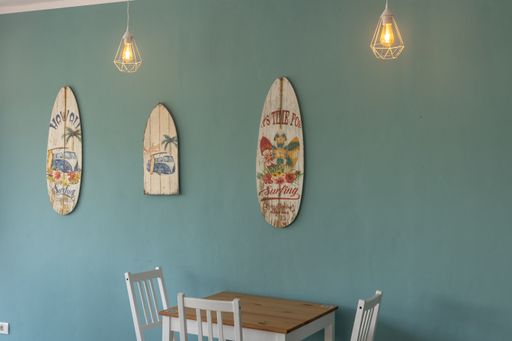 A relaxing vibe of an old wooden surfboard hanged on a wall inside a cafe