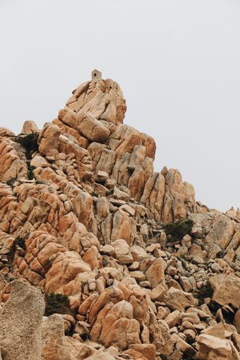 A vertical shot of rock formations under a cloudy sky on a gloomy day