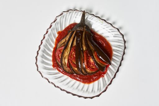 An overhead shot of delicious eggplant with tomato sauce isolated on white background