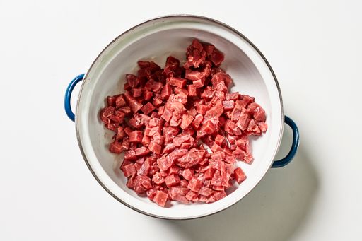 A top view of fresh raw meat cut into small pieces isolated on white background