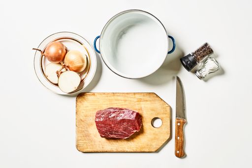 An overhead shot of fresh raw meat with ingredients isolated on white background