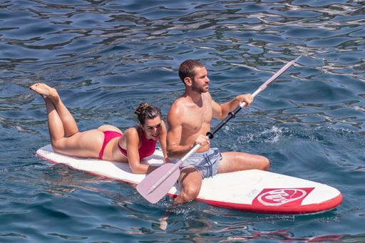 Paddleboard couple having fun paddleboarding together on Ponza beach vacation summer holidays. Ponza, Italy, September 08th 2021.