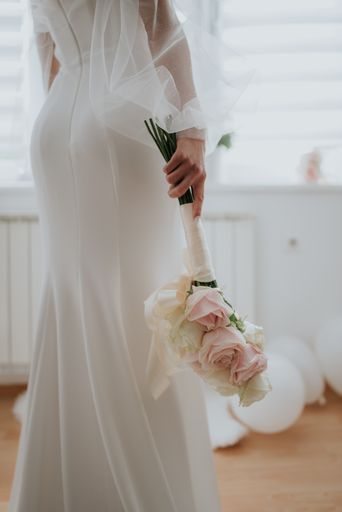 A vertical shot of the bride holding the wedding bouquet