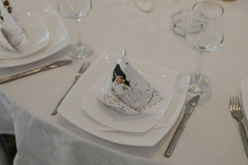 A high angle shot of an empty plate, fork and knife on a table in a restaurant during the wedd