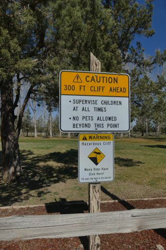A vertical shot of a sign about doggie danger point in Peter Skene Ogden State Park Terrebonne, USA