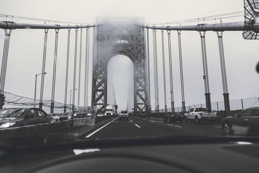 A grayscale shot of cars on an overpass bridge